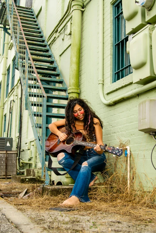 a woman poses for a picture with her guitar