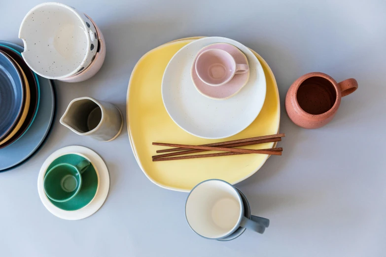 table setting for a dinner with cups, saucers, and saucers