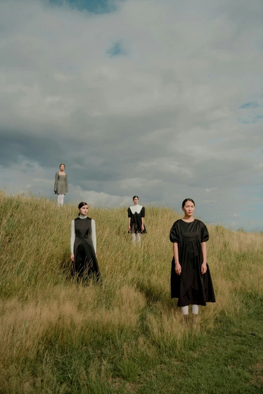 three people standing on top of a lush green field