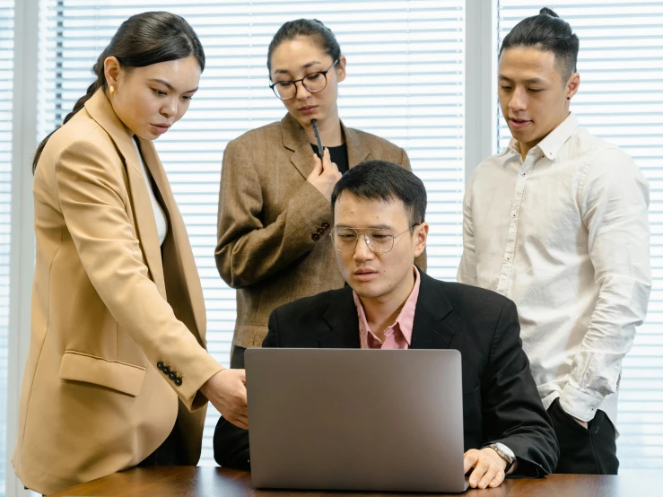 five business people looking at a computer screen