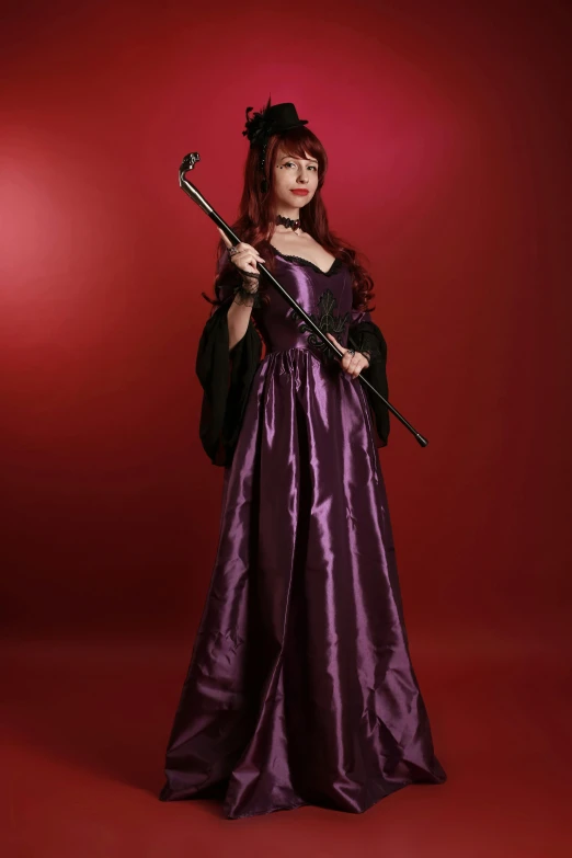 a woman in a long purple dress with an instrument