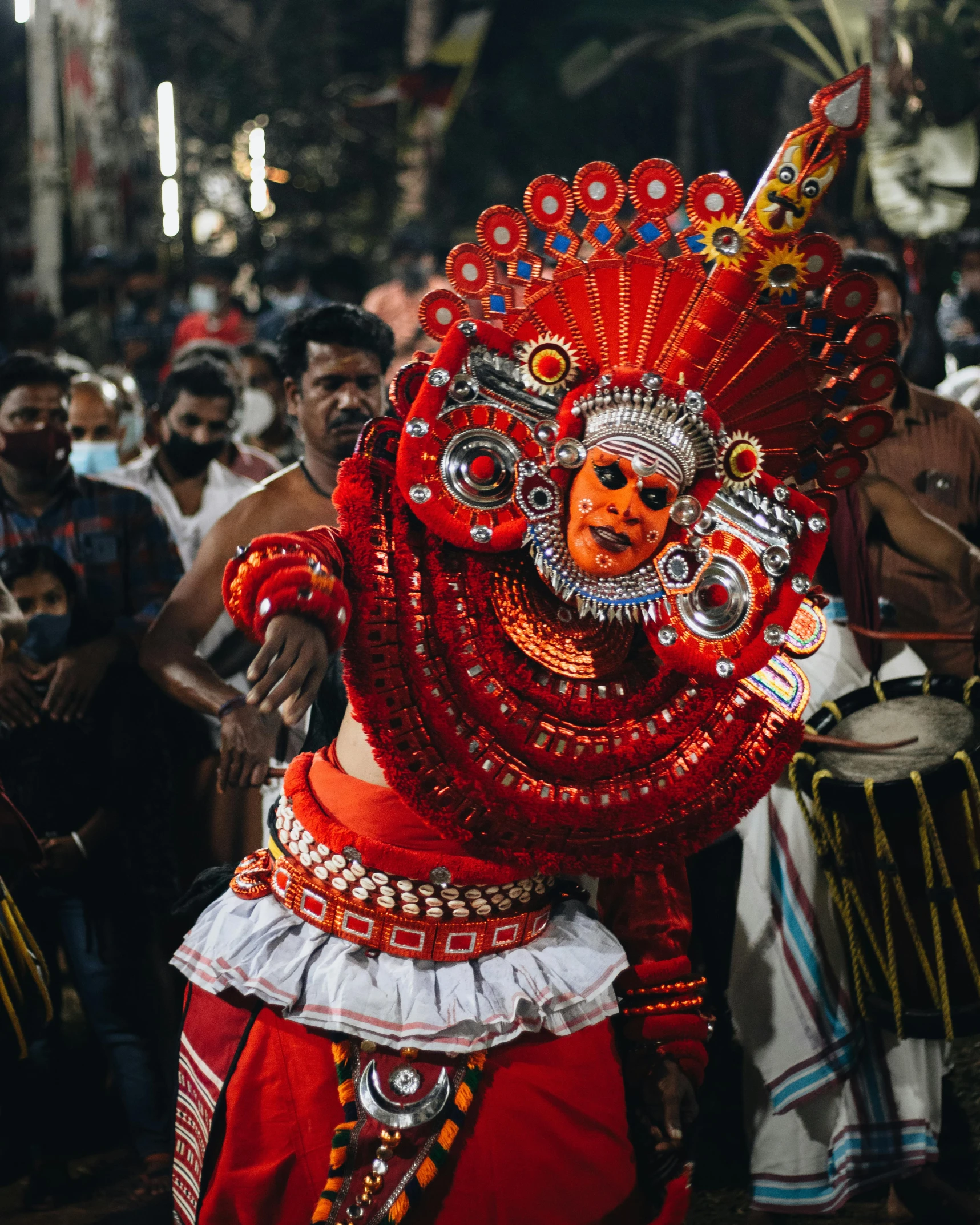 a person in a red mask and headdress