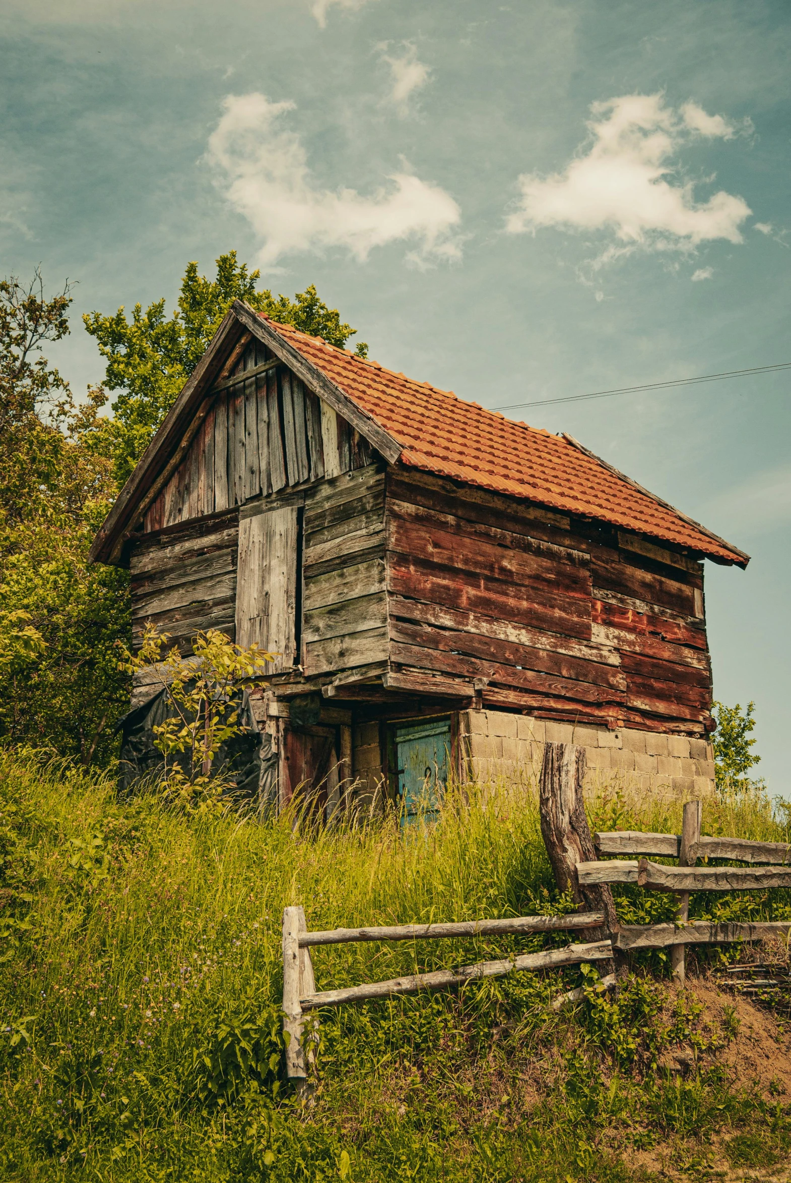 the old wooden building is near a wooden fence