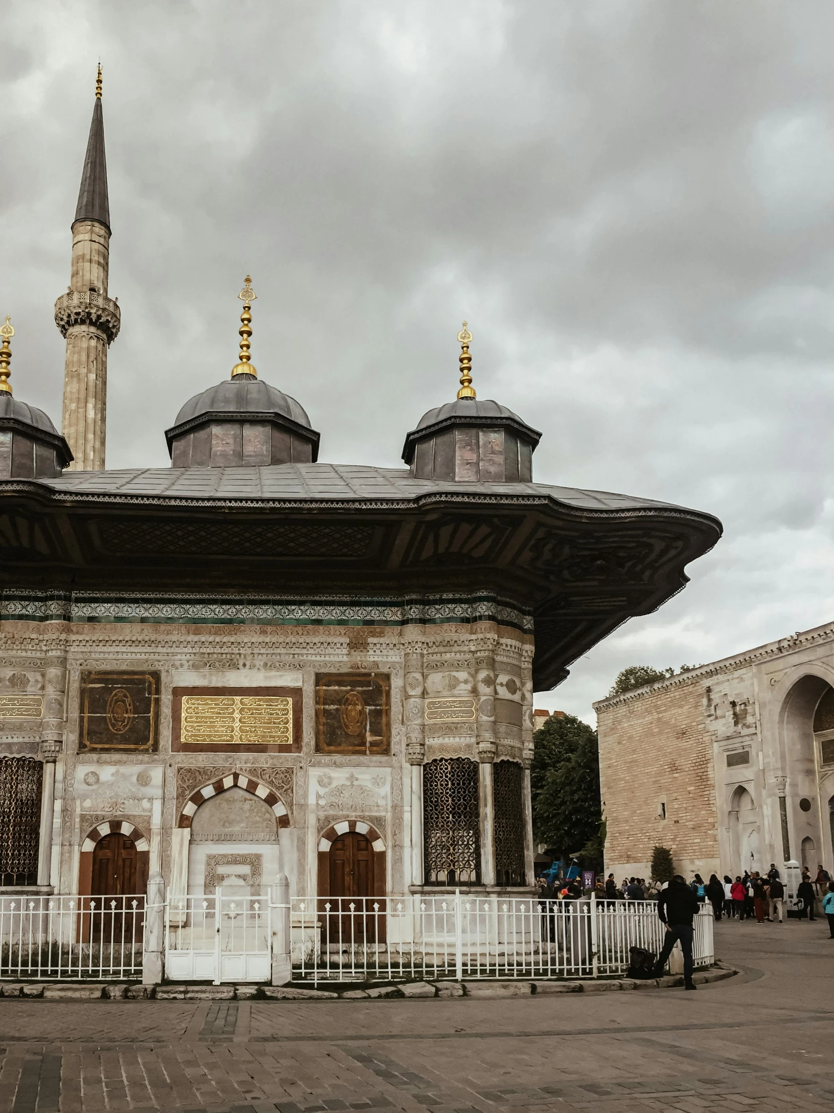 people stand in front of a building with two towers