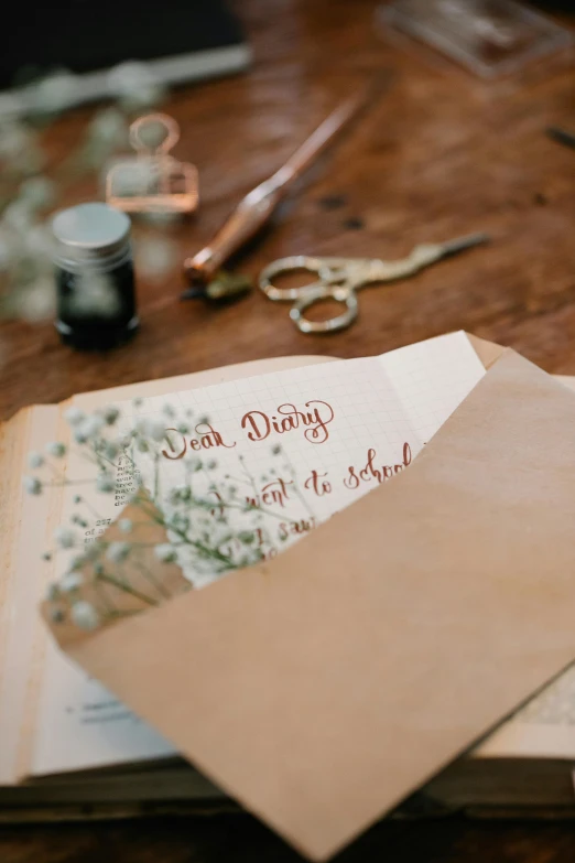 a wooden table has cards, a pair of scissors, and some thread