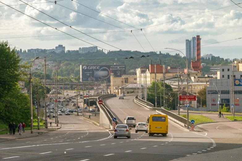 several vehicles on a highway and lots of buildings