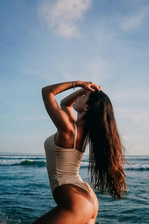 a woman stretching her back at the ocean