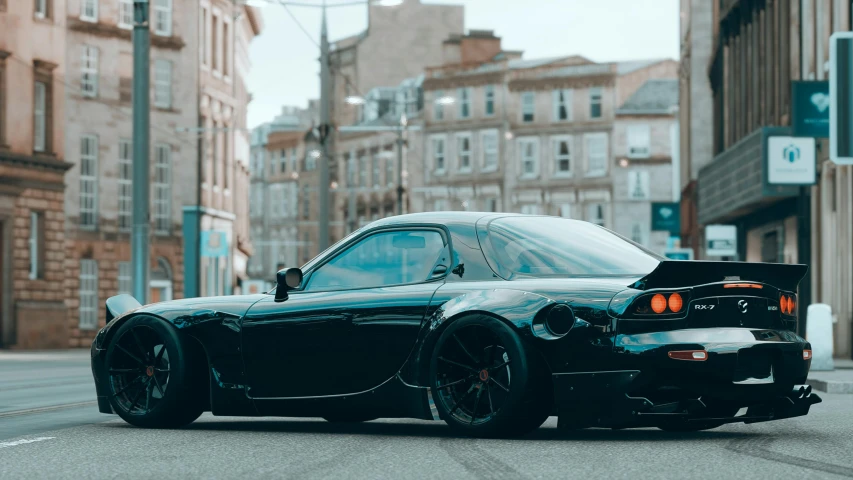 a car in a city street next to a building