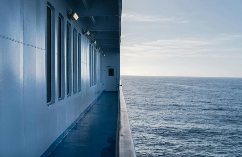 a long walkway leading to the ocean with lots of windows