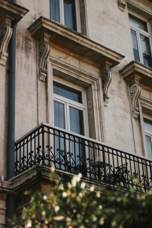 an iron balcony railing is in front of a building