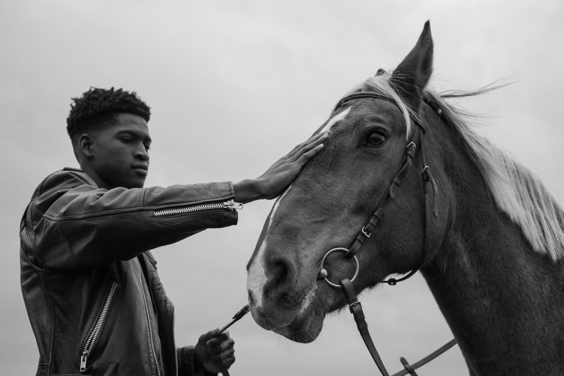 a man with black hair on top of a horse