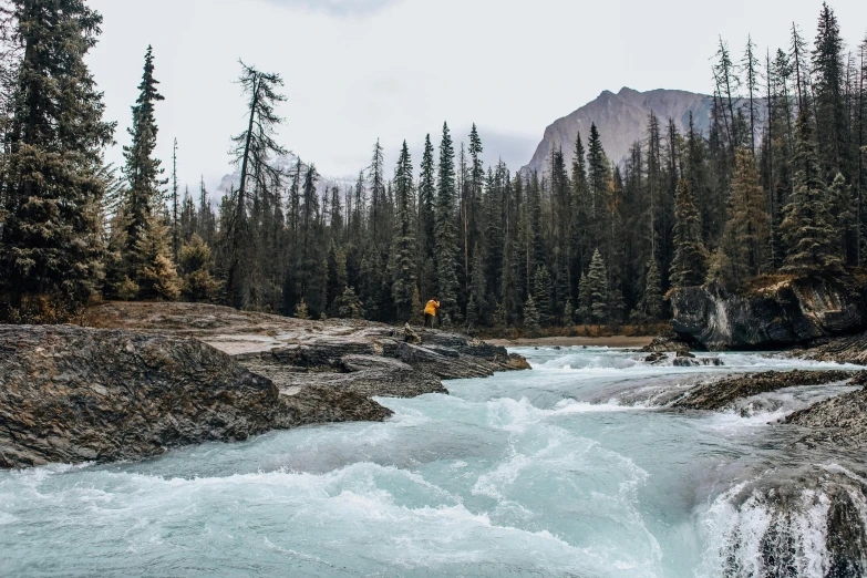 the blue water of the water is rushing beside a mountain