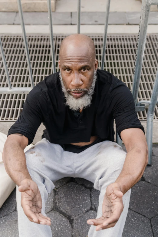 a black man in white pants and black shirt on sidewalk