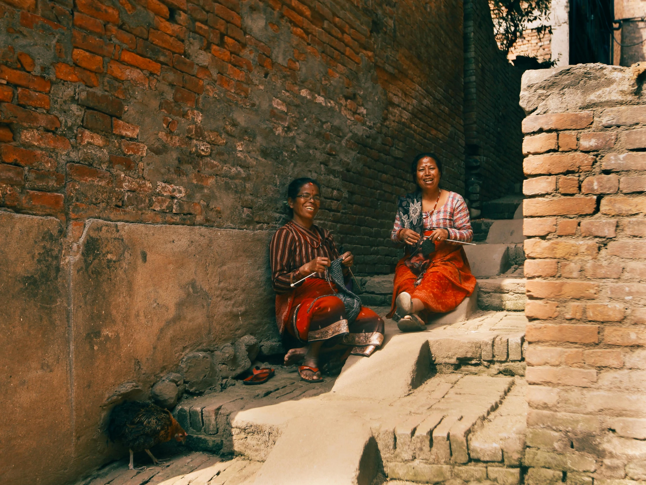 two women sit on steps next to each other