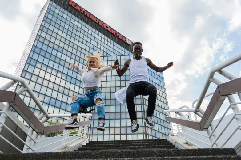 two people in white shirts jumping down some steps