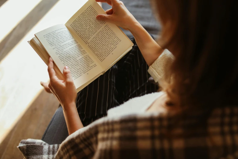 a woman is holding a book with both hands