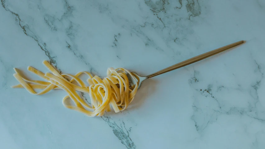 a bowl with spaghetti on a marble surface