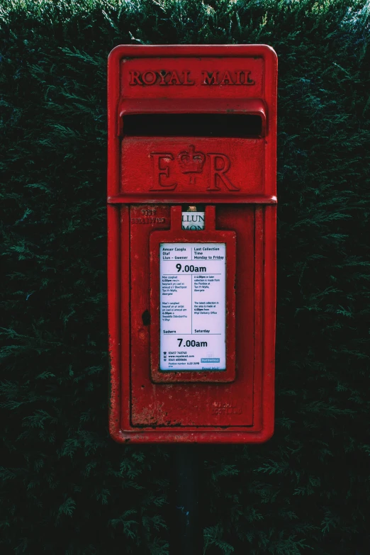 an old fashioned red mail box near a patch of green grass