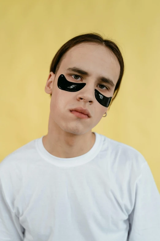 a young man with eye patches looking at the camera