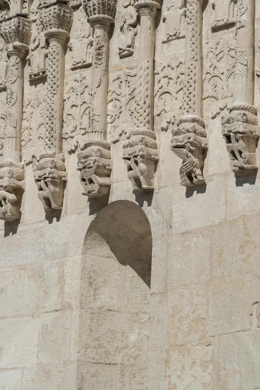 several gargoyle carvings decorate the wall of an ancient building