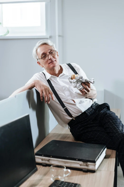 a man sitting at a desk with two laptops on it