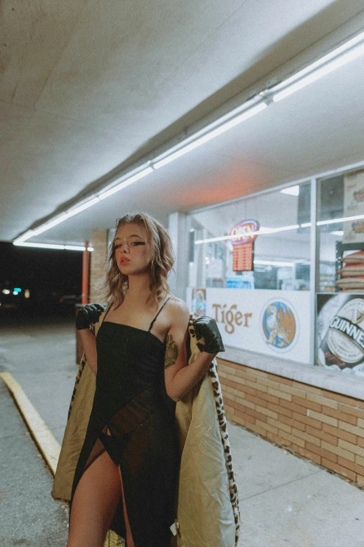 young woman walking through a train station with a robe over her shoulders