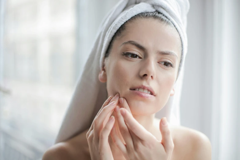 a woman putting her hands under her face as she looks at the camera