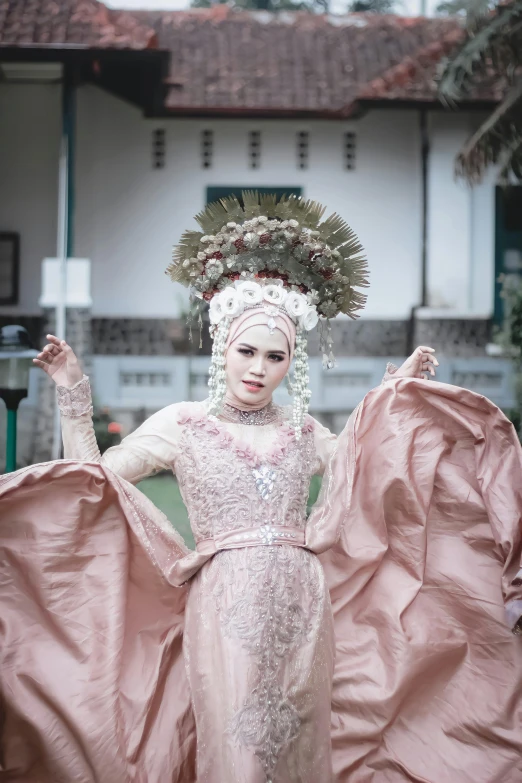 a woman wearing a pink dress and a floral head piece