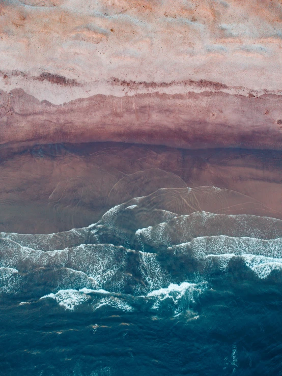 a red and brown water color on the bottom right of a po of rocks on a shore