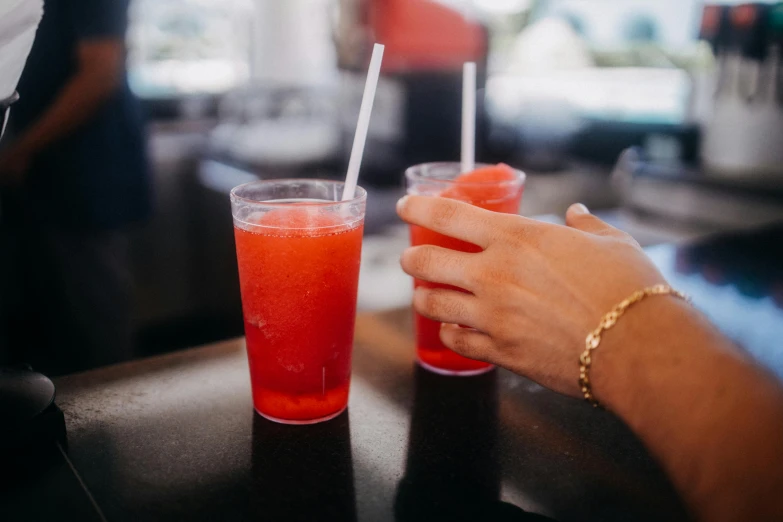 two people sit at a table with two glasses filled with drinks