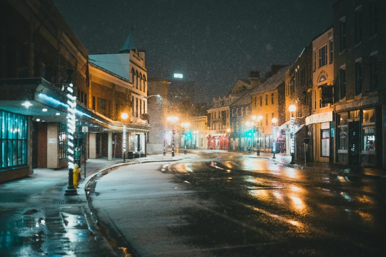 a wet city street with some traffic lights