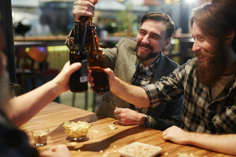 men sitting at table having a beer and ers