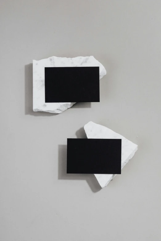 two pieces of white paper with a black one