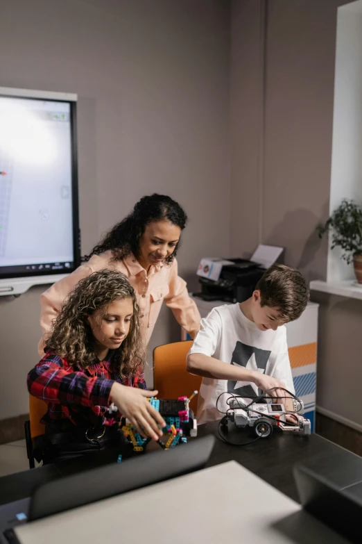 four children are playing with toys at a desk