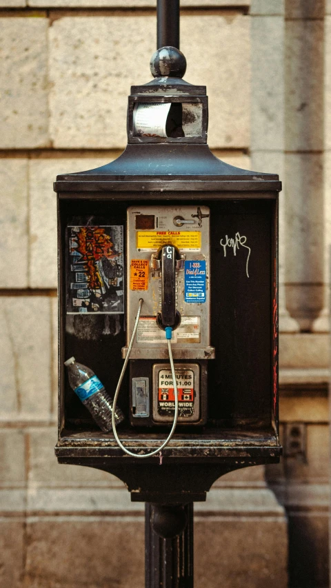 a telephone on a pole outside next to a building