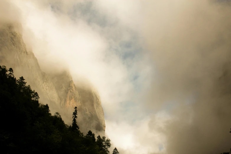 fog rolling through the mountains as seen from below