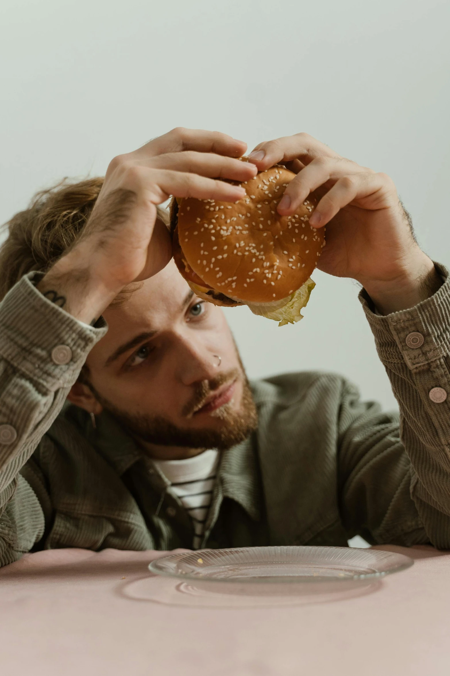 a man sitting at a table looking at a large hamburger