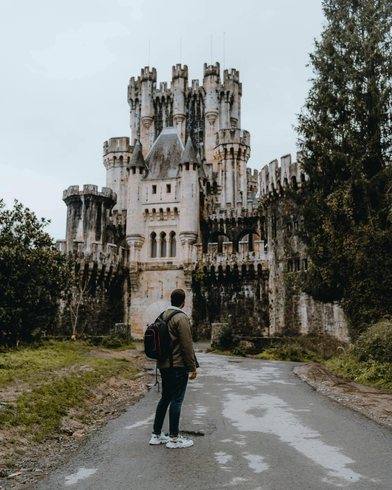 person in front of an old abandoned castle