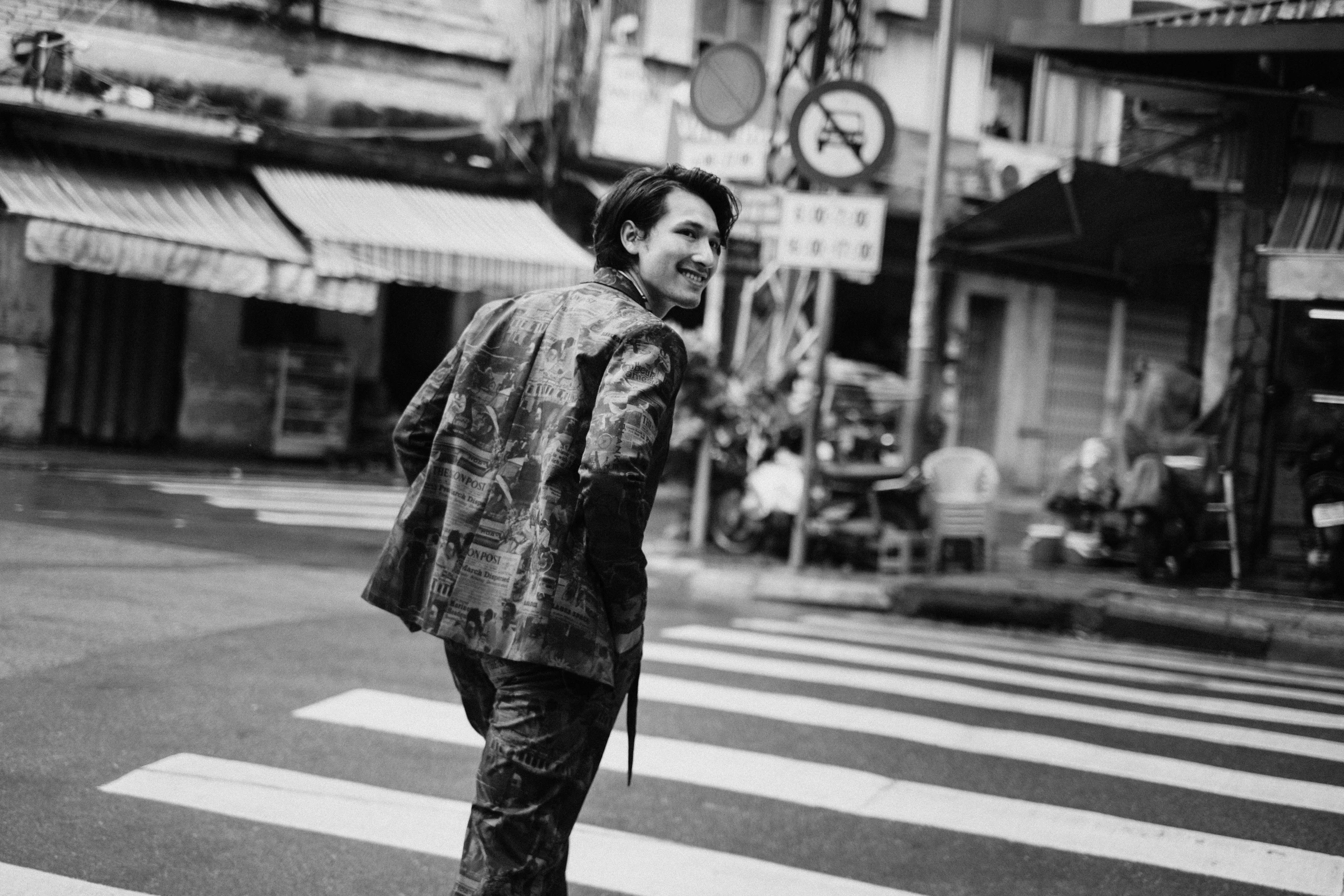 black and white po of a man crossing the street