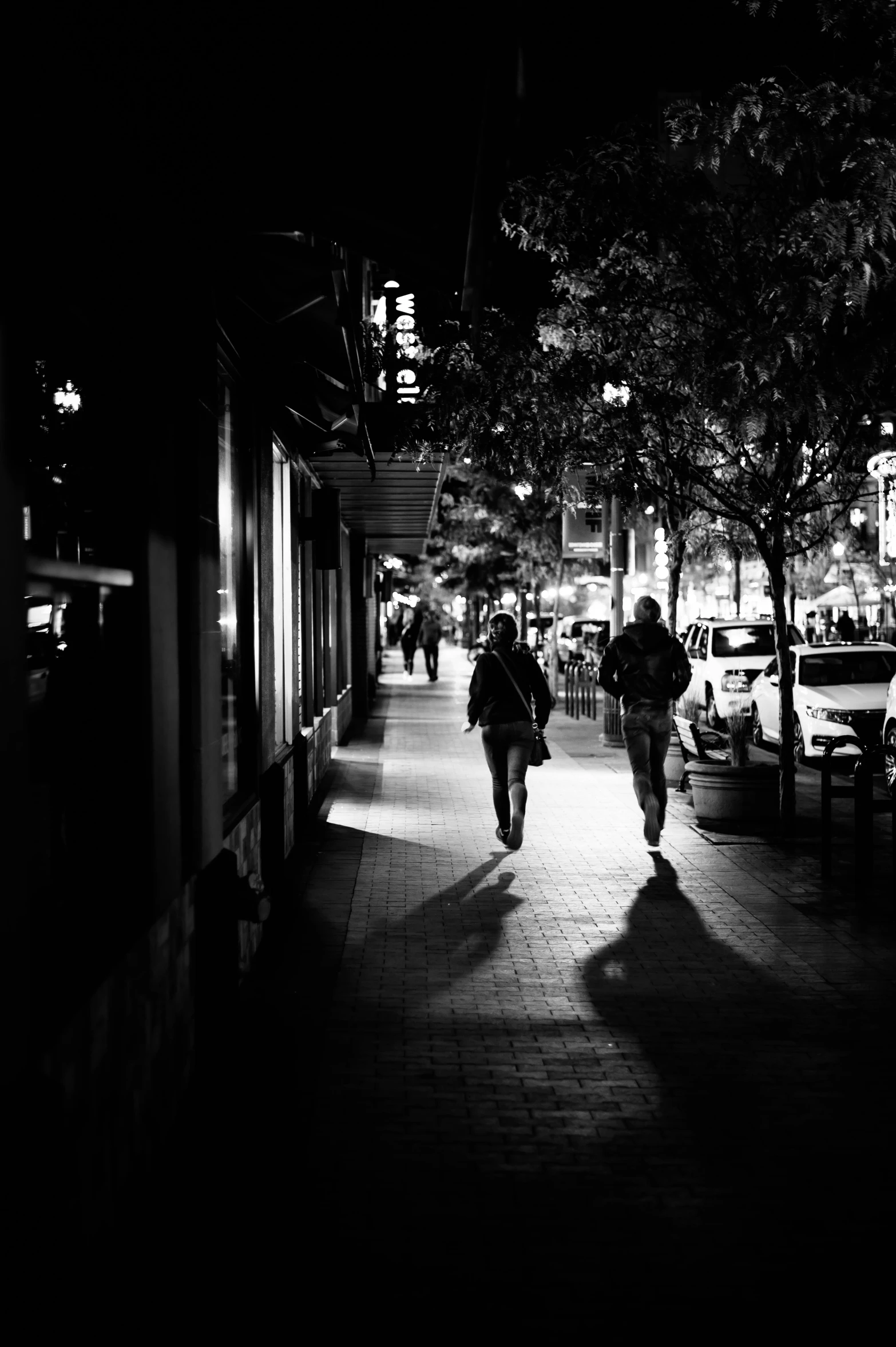 a couple of people walking down a sidewalk