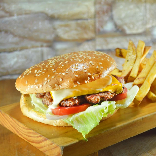 a hamburger and some french fries sitting on a wooden tray