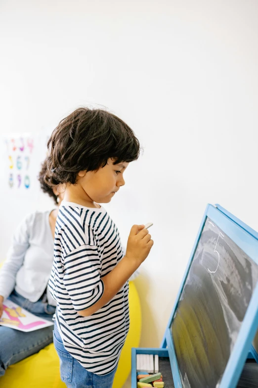 a child writing on a dry erase board