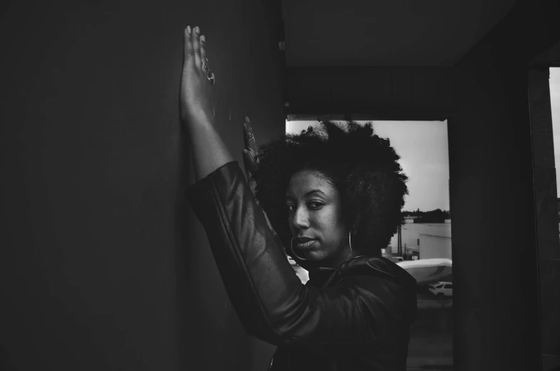 a woman looking out the window with her hand on her shoulder