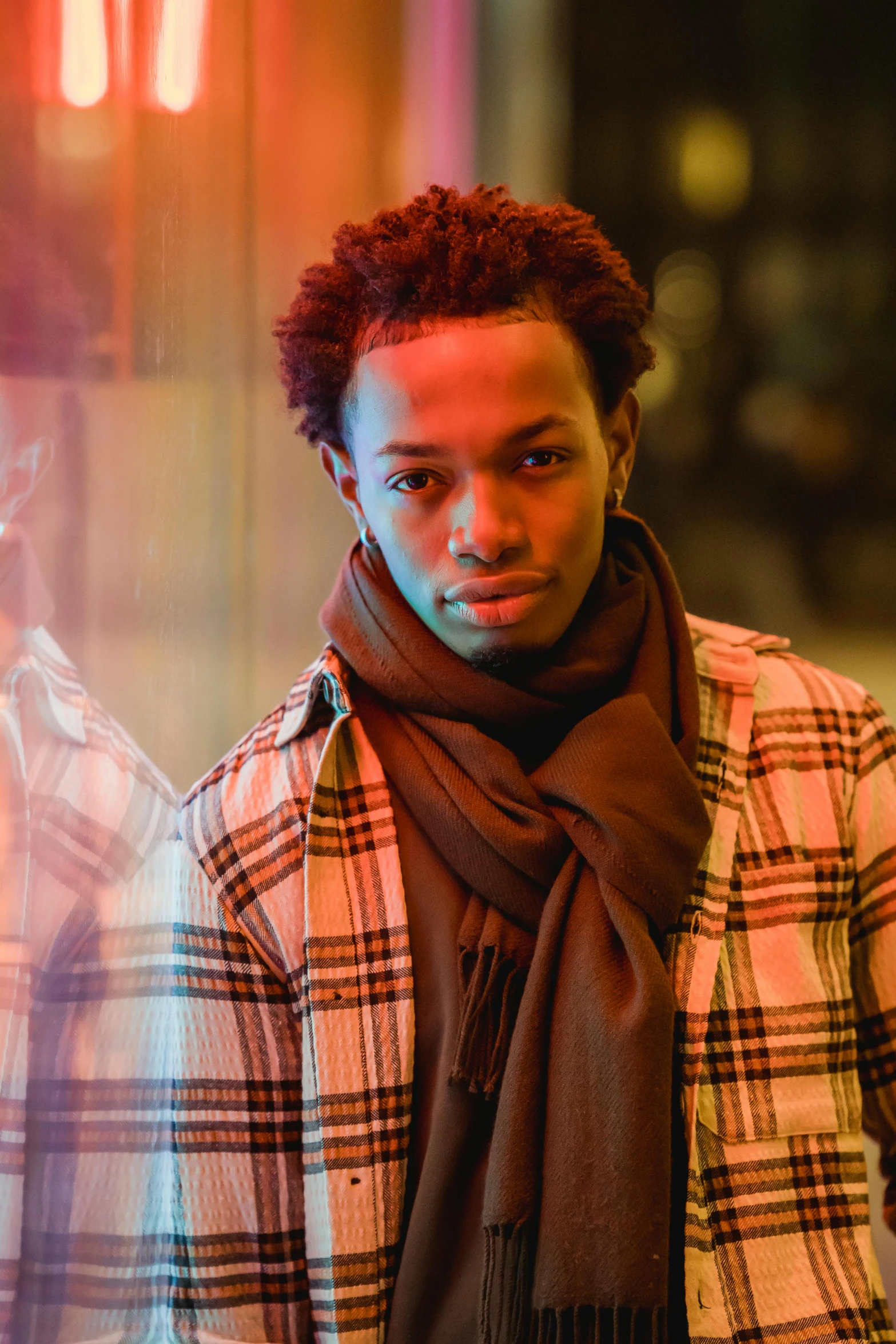 man with dreadlocks stands next to the window