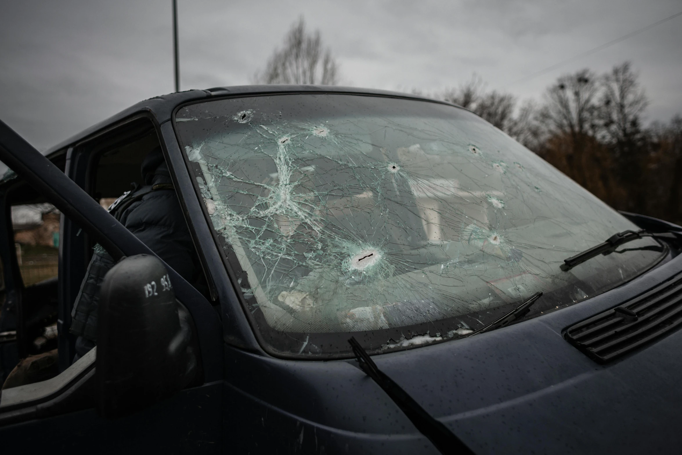 a shattered and battered car has it's door open