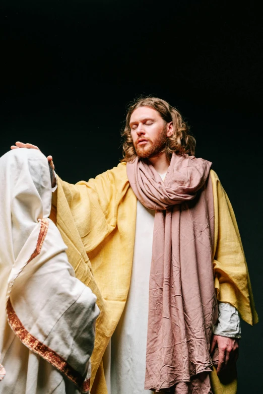 a man standing next to a person dressed in a religious outfit