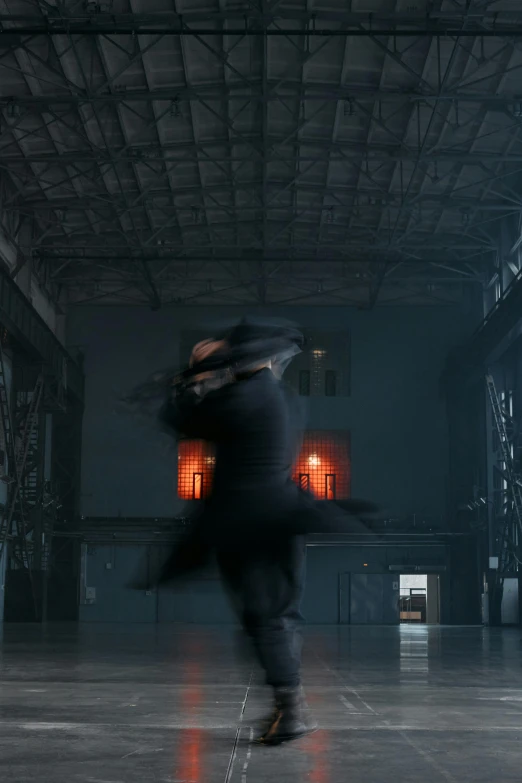 a man walking through a dark industrial hall