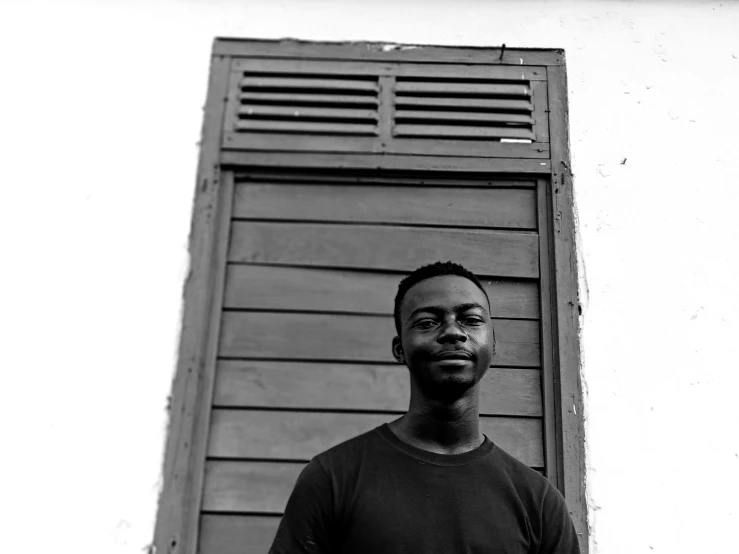 black and white pograph of man in front of wooden door