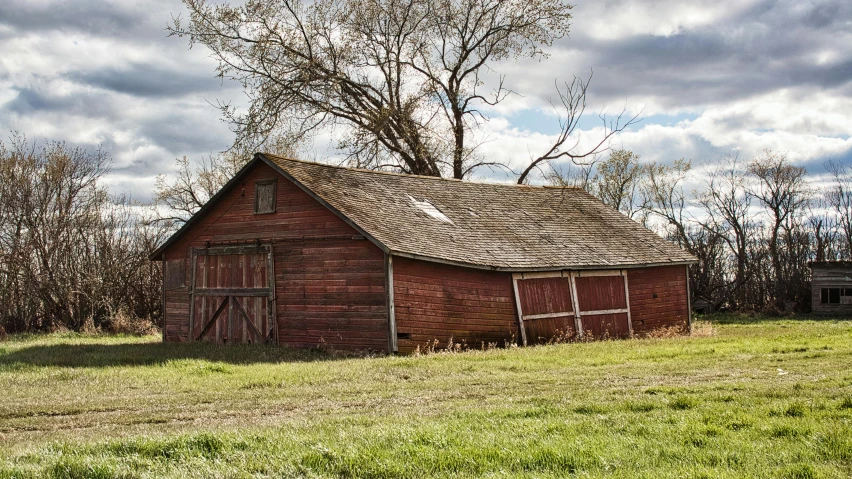 an old, weathered building is in a field