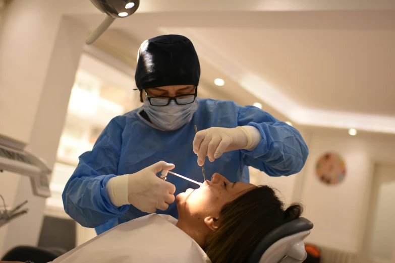 a woman is getting dental help from a dentist